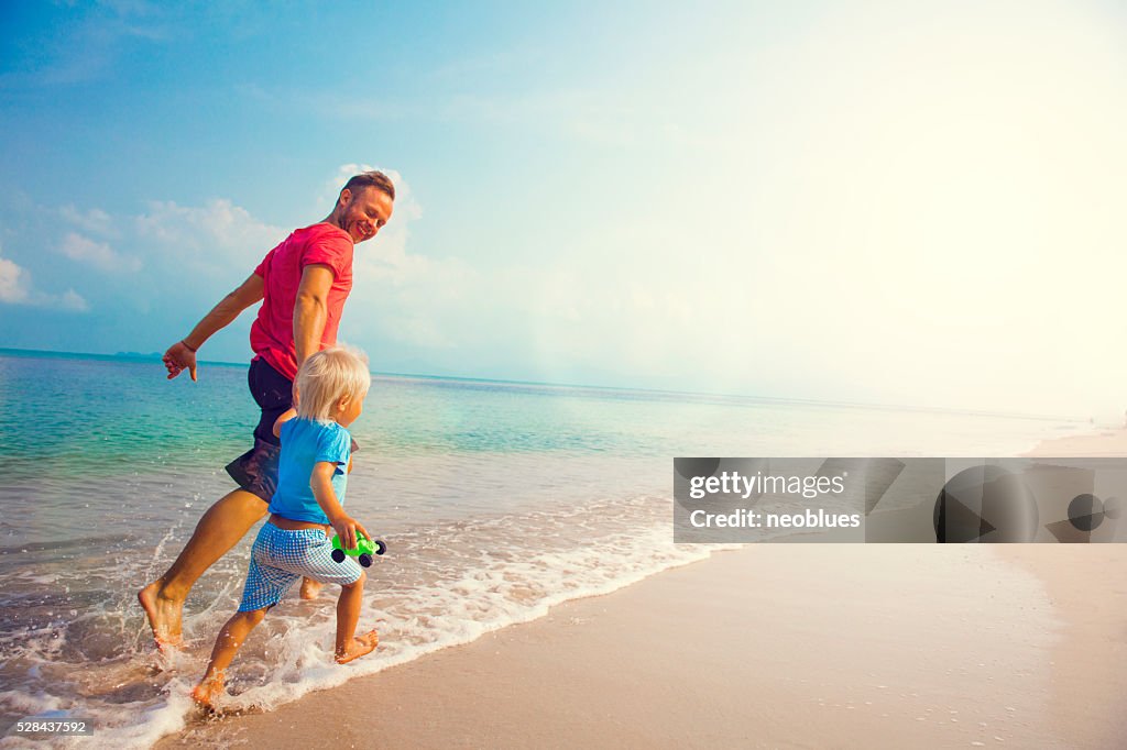 Father And Son Running Along Beach
