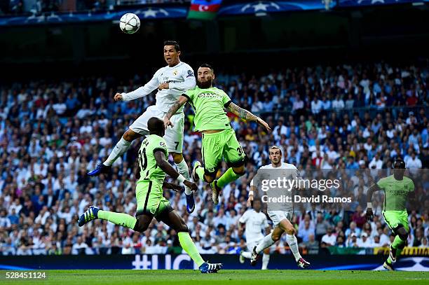 Cristiano Ronaldo of Real Madrid CF heads the ball towards goal under a challenge by Nicolas Otamendi of Manchester City FC during the UEFA Champions...