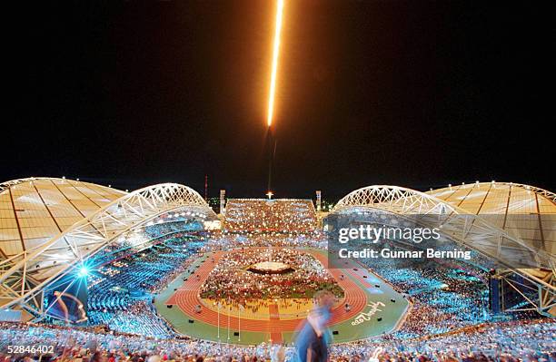 Sydney; Ein Jet ueberfliegt das Olympiastadion in Sydney und "pustet" die Olympische Flamme aus