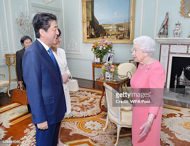 Queen Elizabeth II greets the Prime Minister of Japan Shinzo Abe and wife Akie after they arrived for a private audience at Buckingham Palace on May...