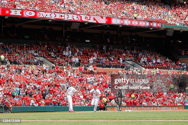 Chris Maloney of the St. Louis Cardinals congratulates Brandon Moss as he runs the bases after hitting a solo home run during the first inning...