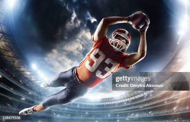 american football player jumping - footballs stockfoto's en -beelden