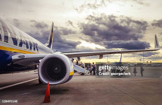 boarding a ryanair flight at sunset - boarding plane stock pictures, royalty-free photos & images