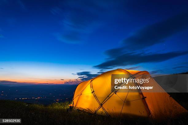 gelber berg zelt beleuchtet bei sonnenuntergang am sommer berg ridge - basislager stock-fotos und bilder