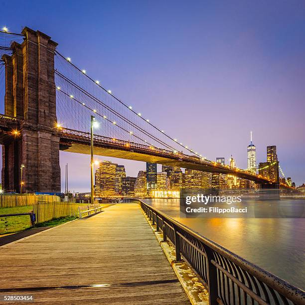 brooklyn bridge und manhattan bei sonnenuntergang - brooklyn bridge park stock-fotos und bilder