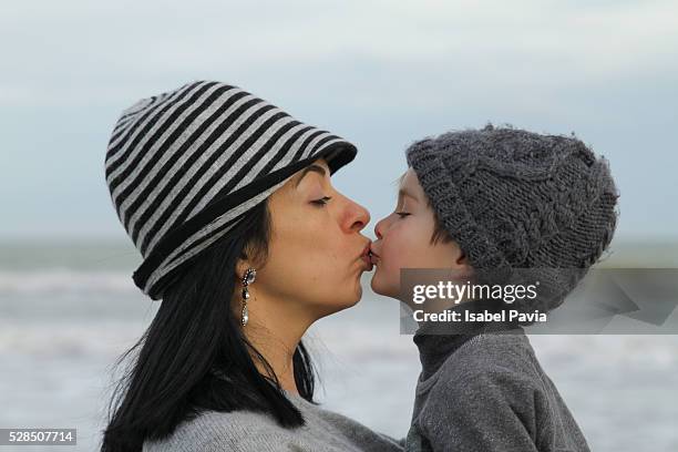 mother kissing her son - monoparental stock-fotos und bilder