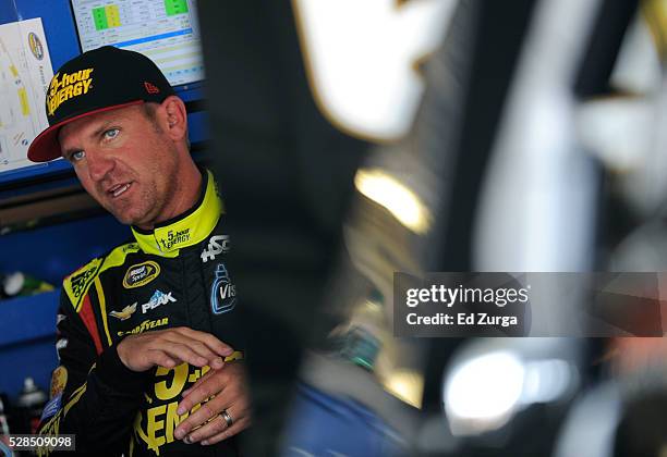 Clint Bowyer, driver of the 5-Hour Energy Chevrolet, talks to a member of his team after a practice sessions for the Toyota Tundra 250 at Kansas...