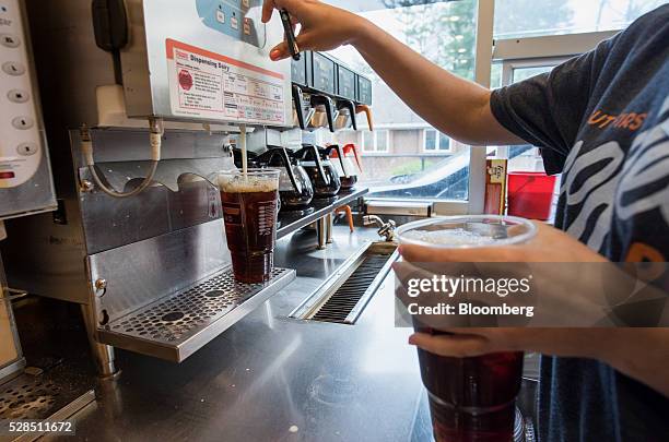 An employee fills coffee orders at the drive thru window inside a Dunkin' Donuts Inc. Location in Ramsey, New Jersey, U.S., on Thursday, May 5, 2016....