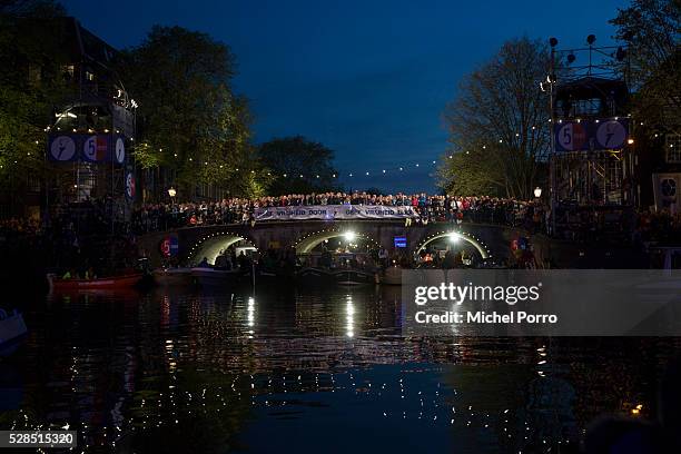 People standing around a banner reading 'Pass On Freedom' watch the Liberation Day Concert on May 5, 2016 in Amsterdam, Netherlands. Liberation Day...