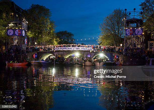 People standing around a banner reading 'Pass On Freedom' watch the Liberation Day Concert on May 5, 2016 in Amsterdam, Netherlands. Liberation Day...