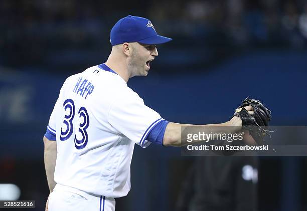 Happ of the Toronto Blue Jays celebrates after getting a double play to end the third inning during MLB game action against the Texas Rangers on May...