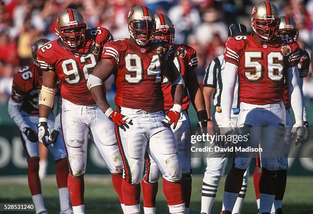 Roy Barker, Dana Stubblefield, and Chris Doleman of the San Francisco 49ers await the next play during a National Football League game against the...