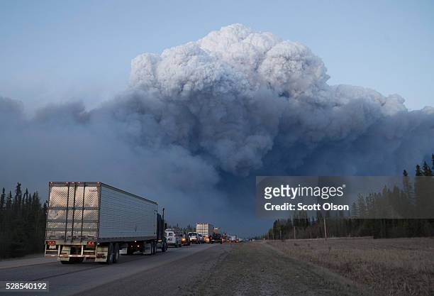 Drivers wait for clearance to take firefighting supplies into town on May 05, 2016 outside of Fort McMurray, Alberta. Wildfires, which are still...