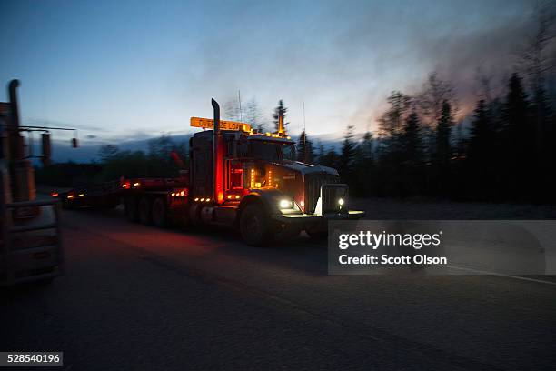 Truck carrying firefighting supplies drives past smoke from a nearby fire on May 05, 2016 near of Fort McMurray, Alberta. Wildfires, which are still...