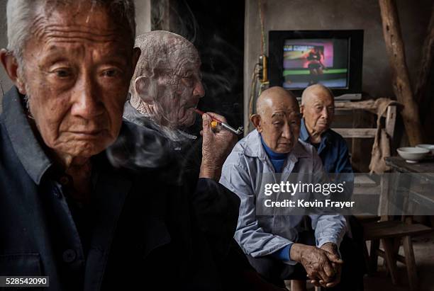 Local village men watch a performance by members of the Jinyuan Opera Company during the group's performance for villagers at the Dongyue Temple on...