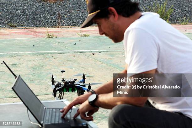 young businessman operates an unmanned aerial vehicle (uav). - drone pilot stock pictures, royalty-free photos & images