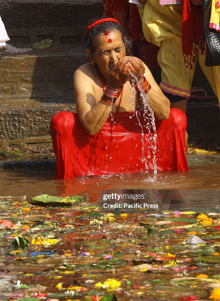 A devotee offers prayer and takes holy bath at a pond  on...