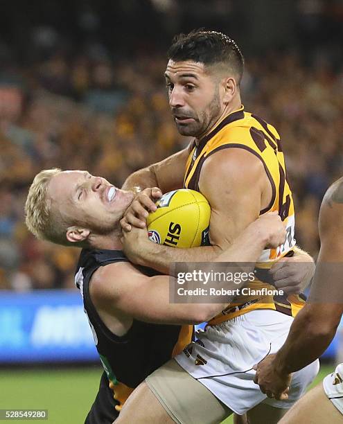 Paul Puopolo of the Hawks is challenged by Steven Morris of the Tigers during the round seven AFL match between the Richmond Tigers and the Hawthorn...