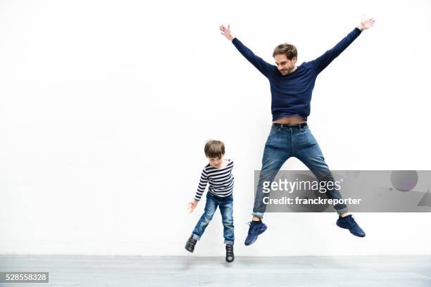 père et fils fils contre le mur blanc - saut et lancer d'athlétisme masculin photos et images de collection