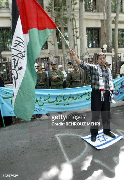 Iranian security forces stand in the background as a Palestinian man