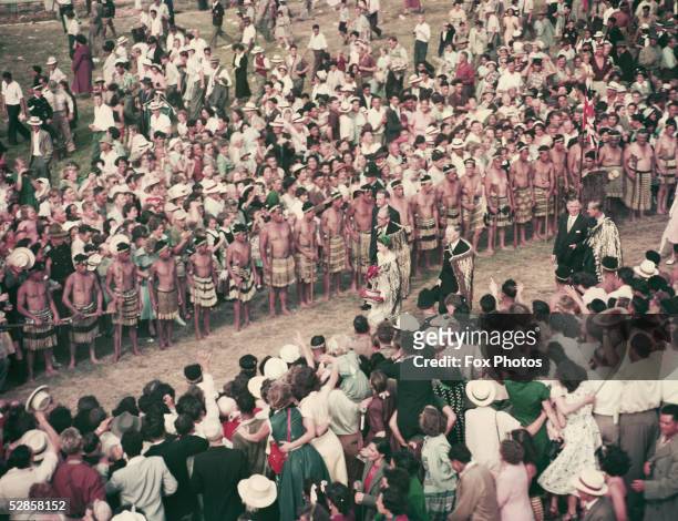 During their foreign tour of 1954, Queen Elizabeth II and Prince Philip, Duke of Edinburgh walk through the crowd at a reception by about 20, 000...