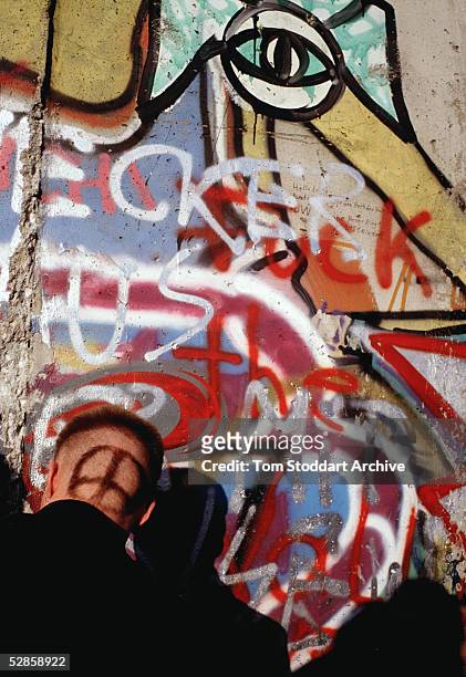 Man with an anti-war symbol dyed into his hair pictured at the Berlin Wall on the day the first section was opened.