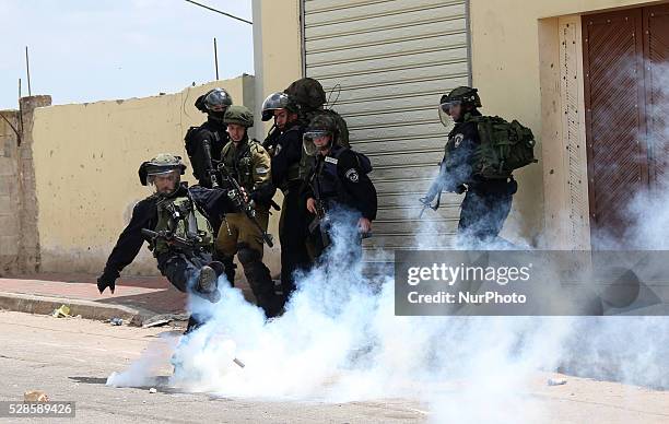 An Israeli soldier throws a tear gas canister towards Palestinian protesters during a protest against the expanding of Jewish settlements in Kufer...