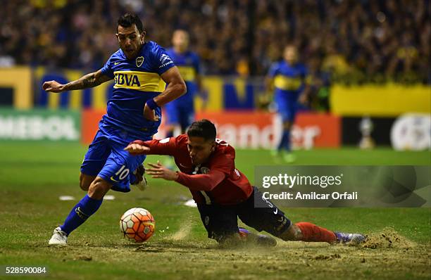 Carlos Tevez of Boca Juniors and Bruno Valdez of Cerro fight for the ball during a second leg match between Boca Juniors and Cerro Porteno as part of...