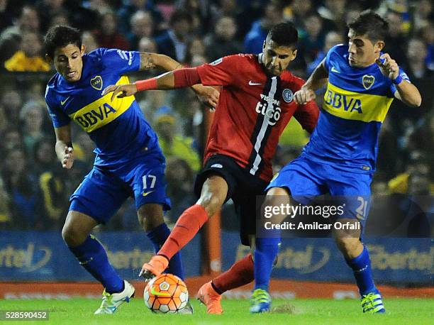 Marcelo Melli and Cristian Erbes of Boca Juniors fight for the ball with Cecilio Dominguez of Cerro Porteno during a second leg match between Boca...