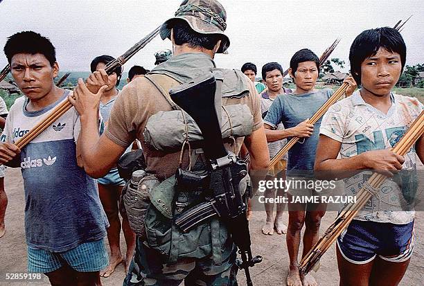 Foto de setiembre de 1994 de un infante de marina cuando inspecciona una formacion de "ronderos" de la etnia Ashaninka, selva central de Peru, como...