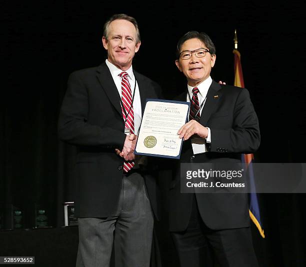 Of the Arizona Small Business Administration Rick Murray receives a proclamation honoring Arizona Small Business Month from Executive Director of the...