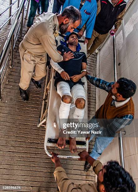 Indian policemen and paramedics carry a wounded Indian policeman on to a gurney inside a hospital after a grenade attack by suspected militants on...