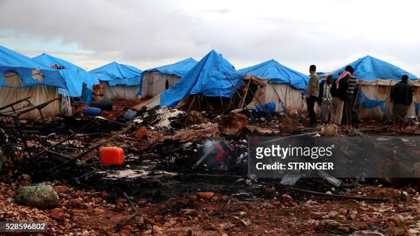 An image grab taken from AFPTV shows Syrian looking at the destruction at a camp for displaced people near the town of Sarmada in Syria's Idblib...