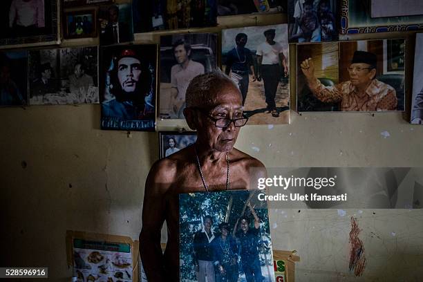 Eko Soetikno, 75 years old, holds his photo with his friends when was imprisoned in Buru island at his house on May 04, 2016 in Kendal, Central Java....