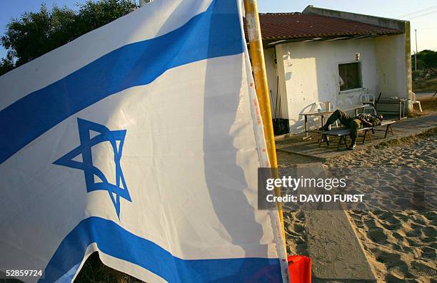 An Israeli soldier takes a rest on a bench outside his barracks in the Jewish settlement of Gadid, located in the Gush Katif settlements bloc in the...