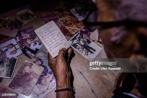 Eko Soetikno, 75 years old, looks at poem written behind the photo when was imprisoned in Buru island at his house on May 04, 2016 in Kendal, Central...