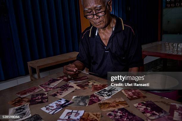 Eko Soetikno, 75 years old, looks at photographs when was imprisoned in Buru island at his house on May 04, 2016 in Kendal, Central Java. Eko, was a...