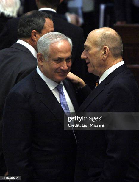 Outgoing Israeli Prime Minister Ehud Olmert speaks with incoming Prime Minister Benjamin Netanyahu during the swearing of a new government in the...