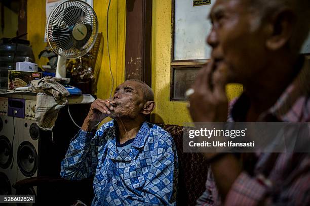 Naryo, 92 years old, smokes inside his house on May 05, 2016 in Kendal, Central Java. Naryo, was a village official who are not connection with any...