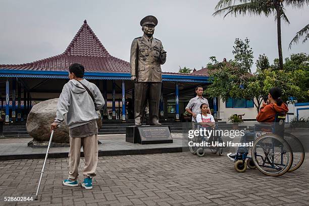 People take a photograph near statue of General Soeharto at Soeharto museum on May 06, 2016 in Yogyakarta, Indonesia. Survivors of Indonesia's...