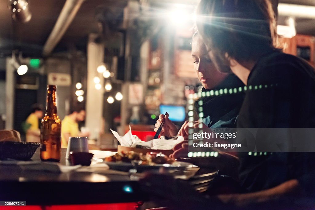 Young people in a club having drink and snack