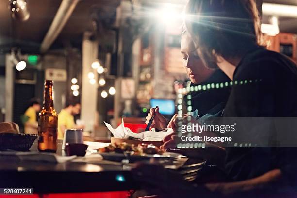 Young people in a club having drink and snack