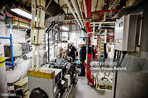 female naval architects in tugboat engine room - boat engine stock pictures, royalty-free photos & images