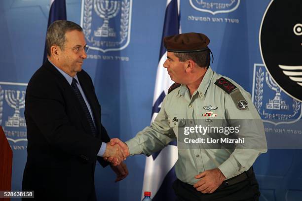 Israeli Defence Minister Ehud Barak shake hands with outgoing Chief of Staff Gabi Ashkenazi during a special ceremony at the Prime Minister's Office...