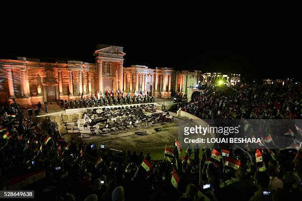 People attend a music concert in the ancient theatre of Syria's ravaged Palmyra on May 6, 2016 following its recapture by regime forces from the...