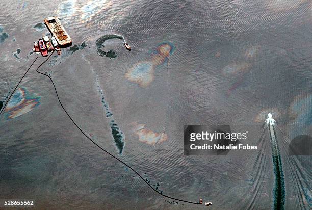 Boats and sorbent boom circle the Exxon Valdez oil spill in Prince William Sound, Alaska, USA, to control the spreading slicks.