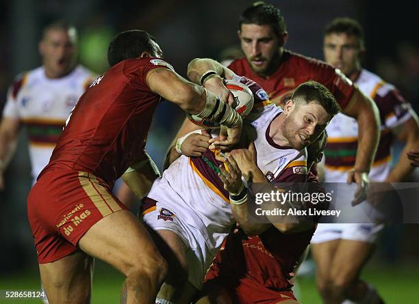 Dave Scott of Batley Bulldogs is tackled by Louis Anderson of Catalan Dragons during the Ladbrokes Challenge Cup Sixth Round match between Batley...