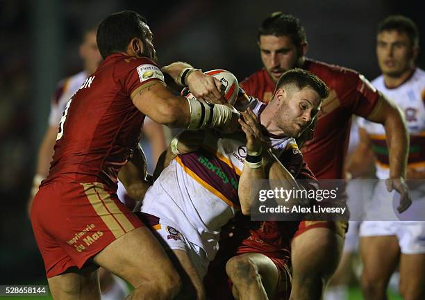 Dave Scott of Batley Bulldogs is tackled by Louis Anderson of Catalan Dragons during the Ladbrokes Challenge Cup Sixth Round match between Batley...