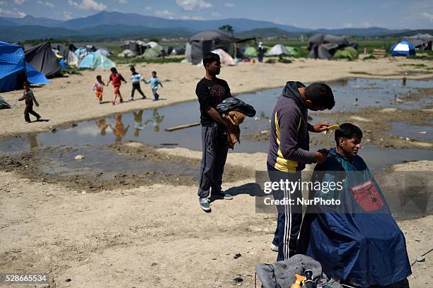 Refugee is getting a haircut from another refugee on May 6'th, 2016 at Idomeni refugee camp. Thousands of migrants are still stranded in the...