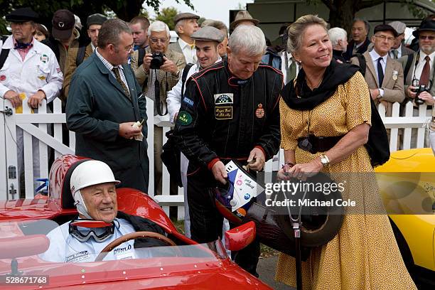 Sir Stirling Moss sitting in his 1958 OSCA FS372 with driver Roger Earl and Stirling's wife Susie on right